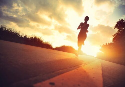 young fitness woman runner running on sunrise trail